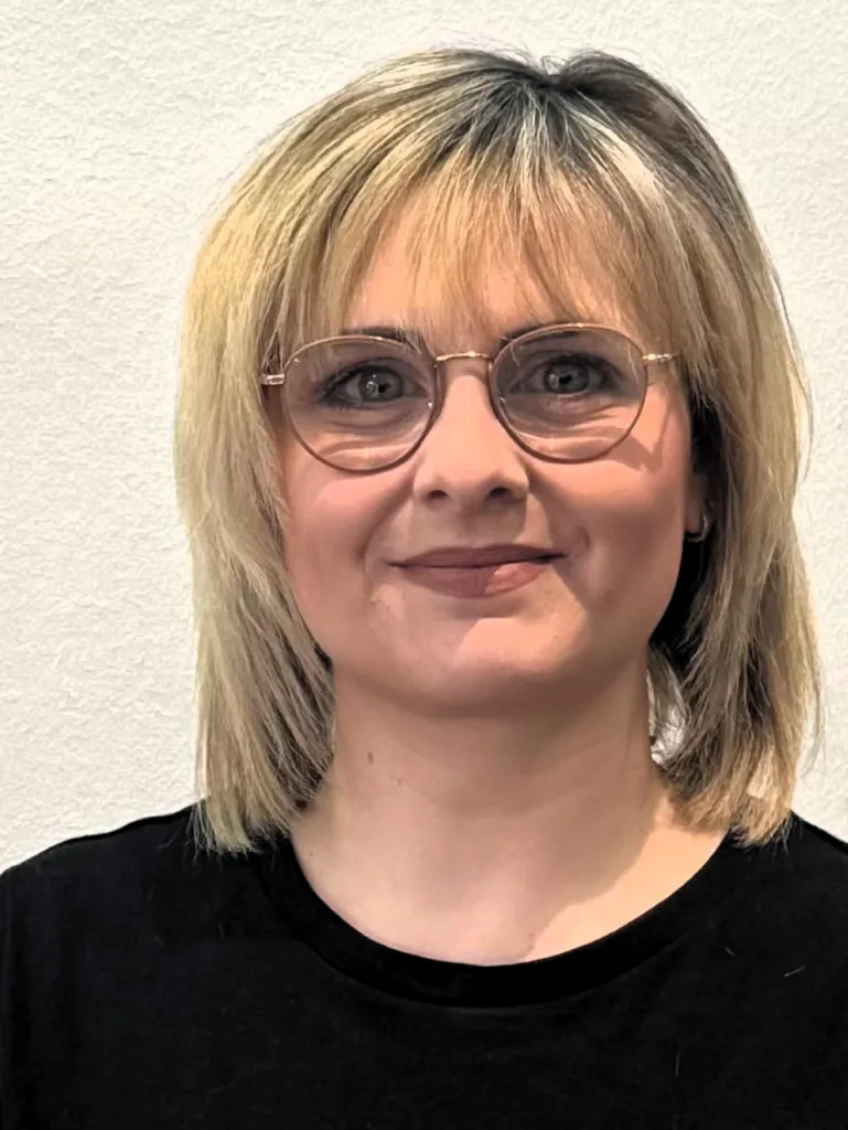 Porträt von Lilia. Sie hat schulterlange Haare und schaut in die Kamera.