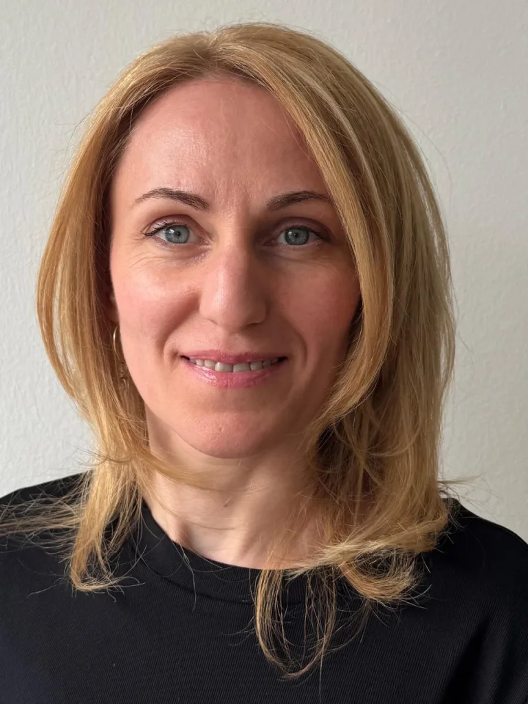 Porträt von Yana. Sie hat blondes, schulterlanges Haar.