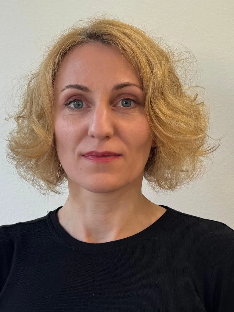 Porträt von Yana. Sie hat blondes, schulterlanges Haar.