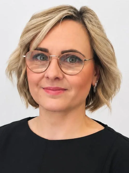 Porträt von Lilia. Sie trägt eine Brille und hat kinnlanges Haar.